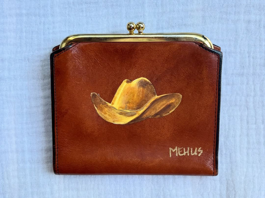 hand-painted cowboy hat on a vintage brown leather wallet