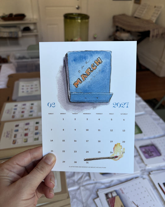 march 2027 postcard from the arthus calendar held in hand, blue watercolor matchbook inspired by bar primi