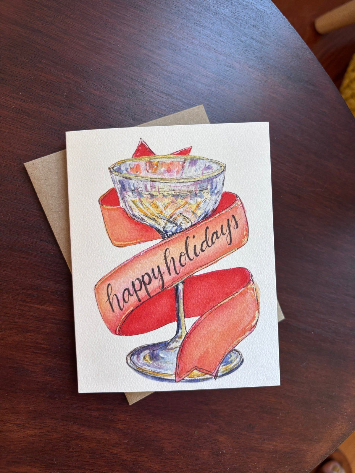 happy holidays champagne greeting card front on a kraft envelope