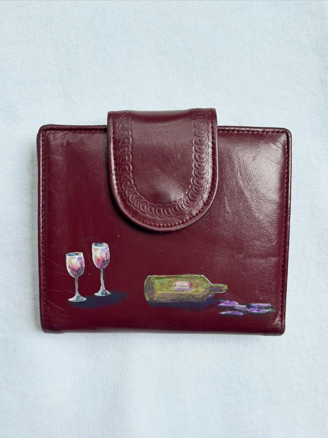 wine glasses and a bottle hand-painted on a vintage burgundy buxton leather wallet